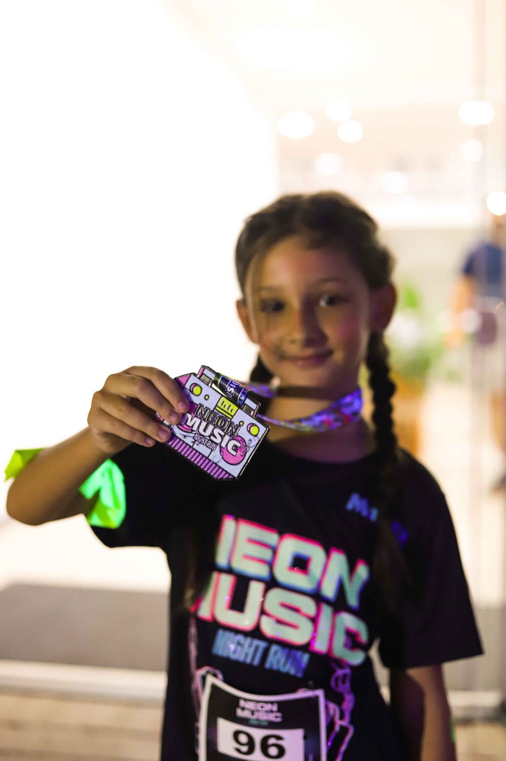 Criança exibindo medalha da NEON