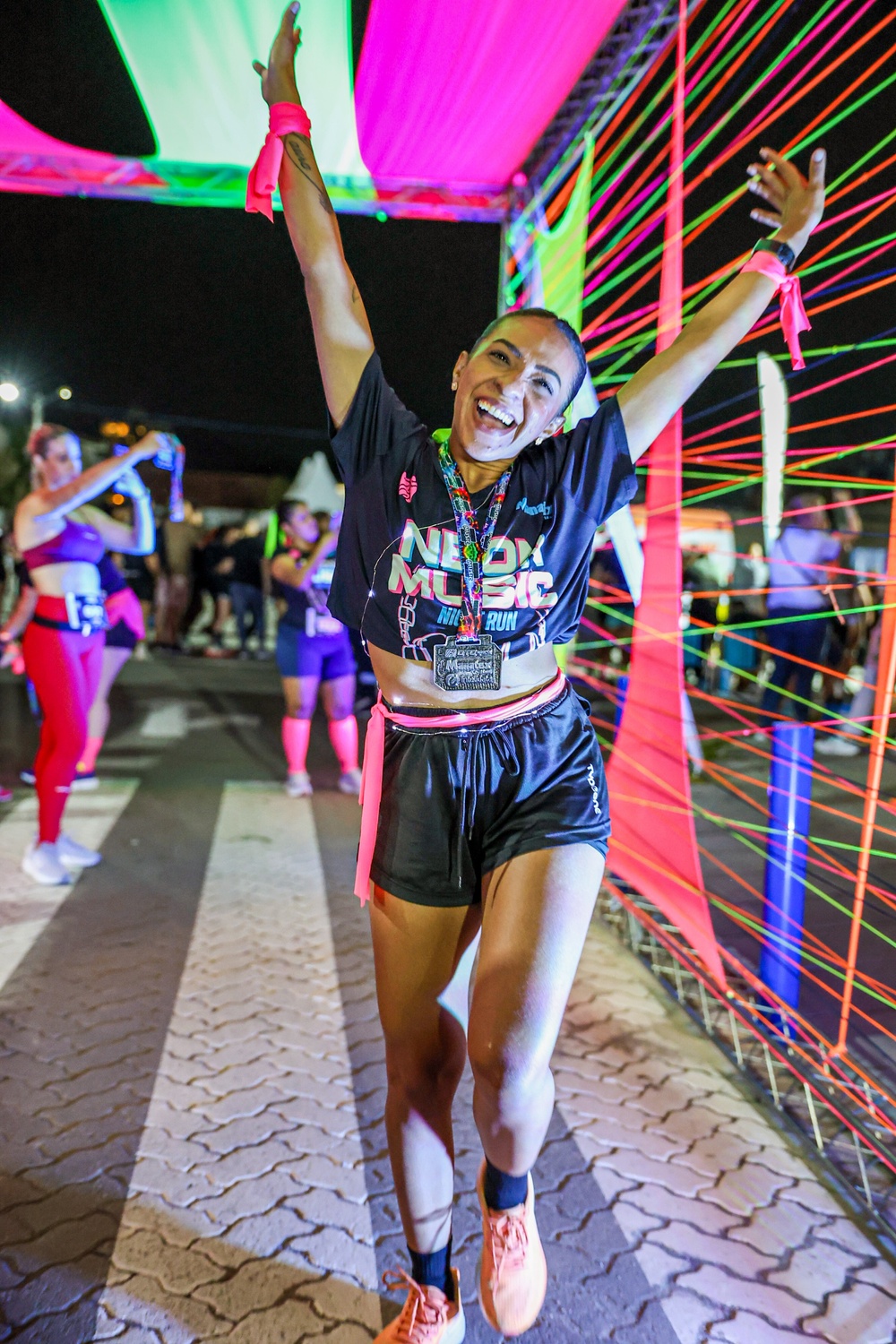 Corredora comemorando com medalha na chegada